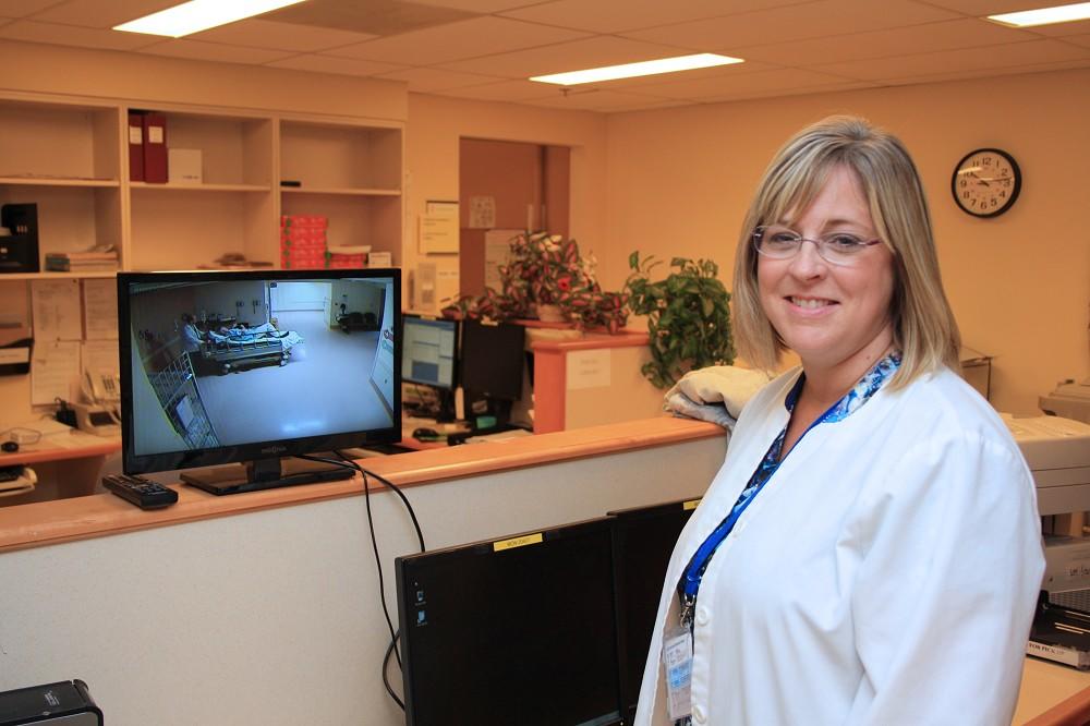 Julie Grant, Charge Technologist of General and Interventional Radiology, demonstrates how staff can now see all patients waiting in the stretcher bay thanks to a new video “window” purchased with a Family CARE Grant.