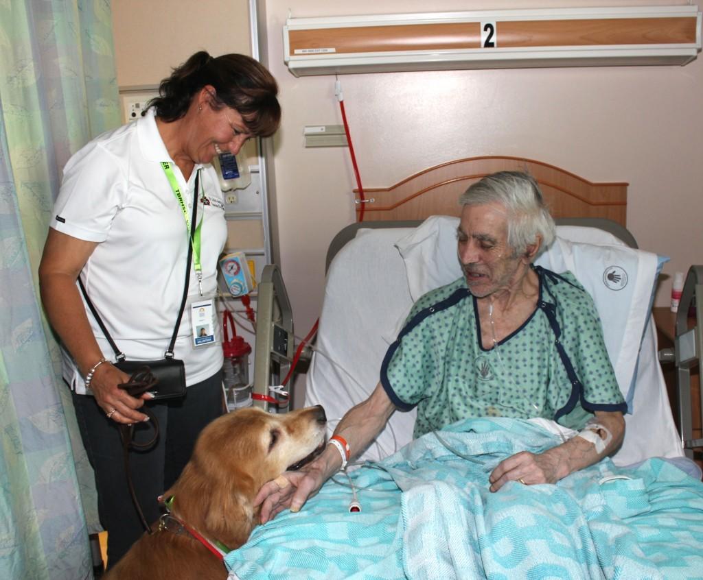 Denver frequently visits with senior patients enrolled in the Hospital Elder Life Program (HELP) as a way to help relieve stress and brighten their spirits during their stay at the Health Sciences Centre. Here, Denver and Susan are bringing some joy to HELP patient Nicodemus Bloom.