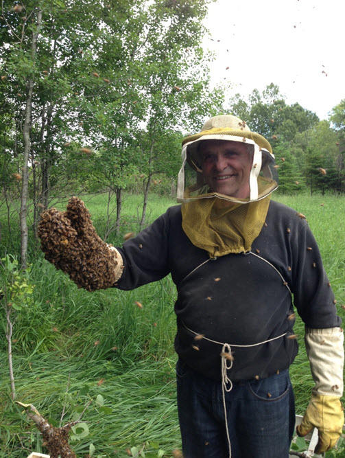 Rudy Kuchta, of Kuchta Honey Farm, posing with a swarm of his honeybees. Kuchta Honey Farm sells local, unpasteurized honey at Thunder Bay Regional Health Sciences Centre’s (TBRHSC) Fresh Market on Wednesdays from 11:30 am to 1:30 pm.