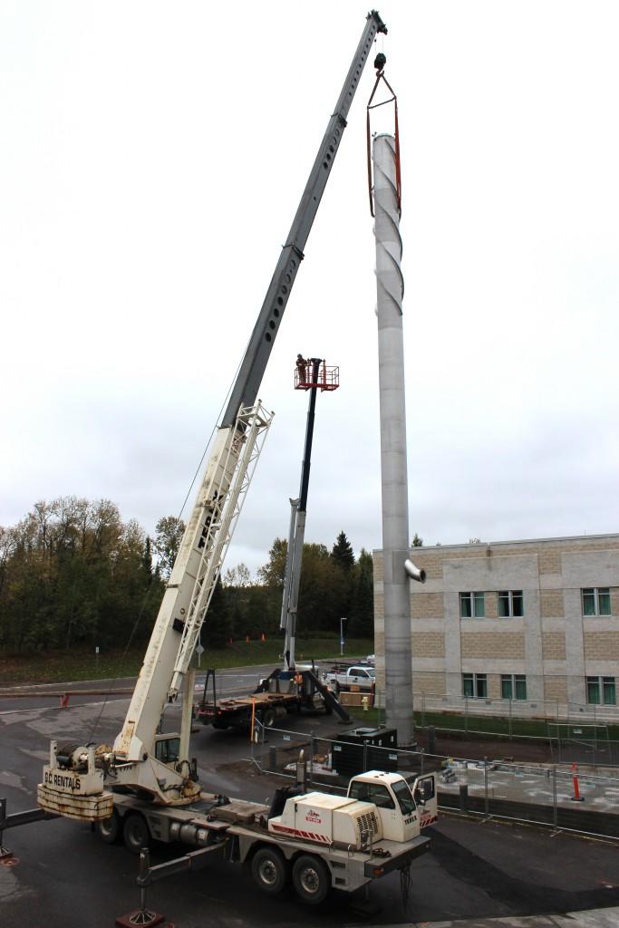 Workers complete the installation of the 100-foot-tall stack component of TBRHSC’s new Combined Heat and Power (CHP) plant on Friday, September 25, 2015.