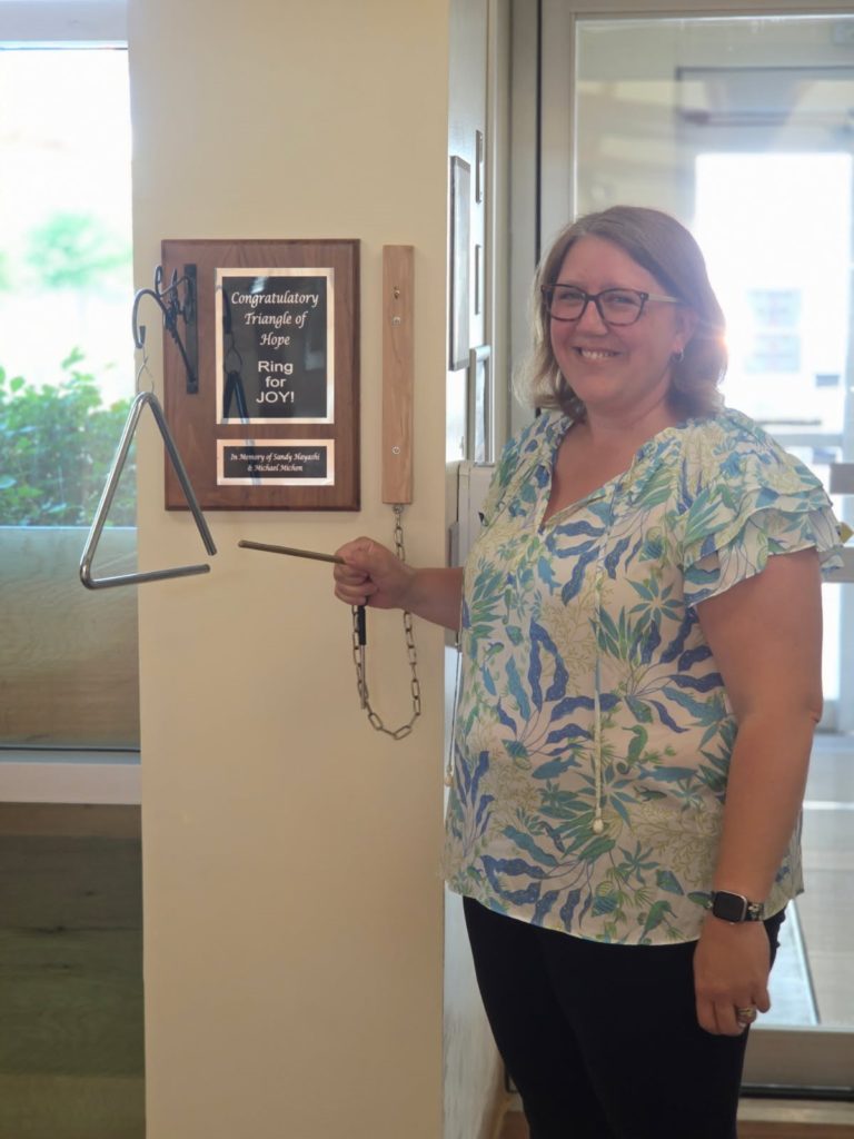 Kirsten Kay ringing the bell at Thunder Bay Regional Health Sciences Center’s Regional Cancer Care, marking the end of her radiation treatment.